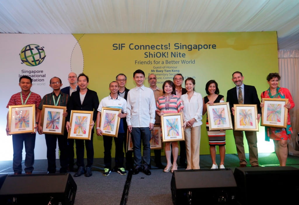 Guest-of-honour Parliamentary Secretary Mr Baey Yam Keng joins on stage for a commemorative group photo with award recipients recognised for their contributions to support the work of the SIF over the past few years