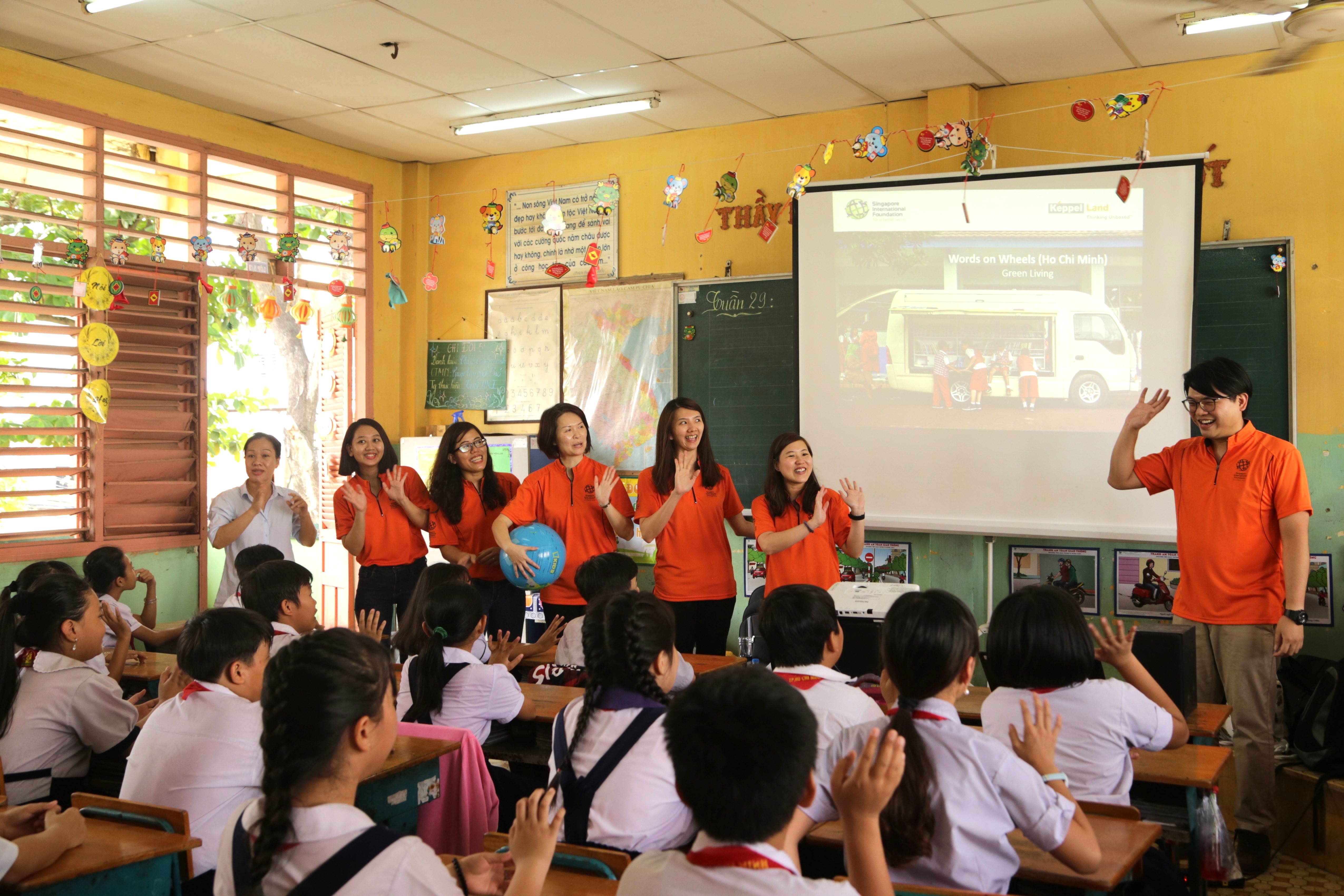 Volunteers standing in front of a classroom of students